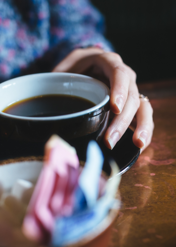 Lidt sløret billede med en kaffekop i fokus med kaffe i.