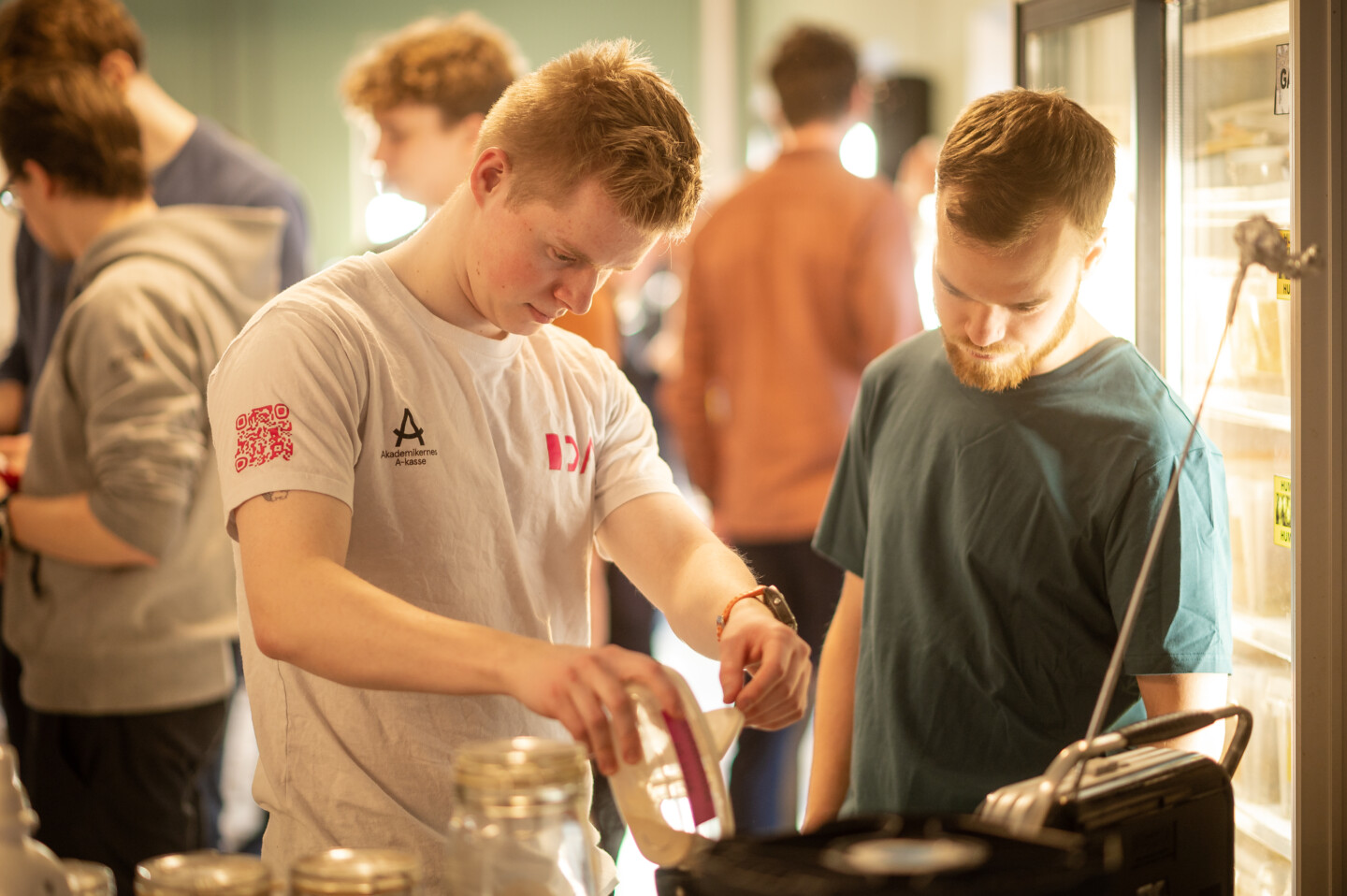 To drenge står til et øl brygningsevent og nærstuderer noget