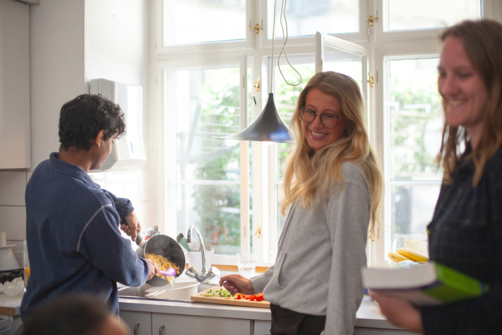 Studerende der står i et køkken og laver mad